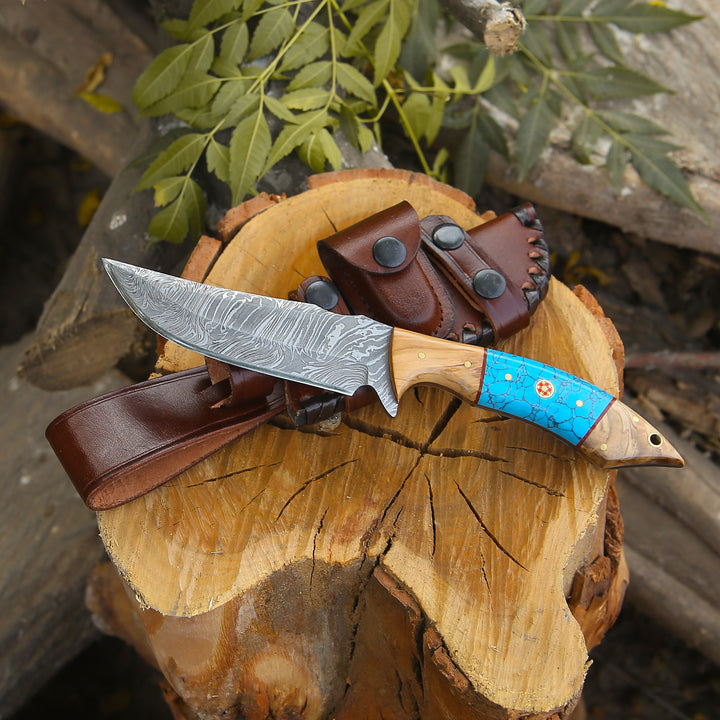 Knife with a blue handle on a wooden log with a leather sheath.