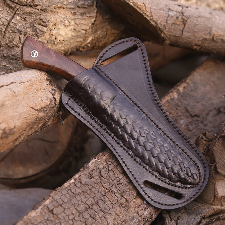 Knife with a leather sheath on a wooden background
