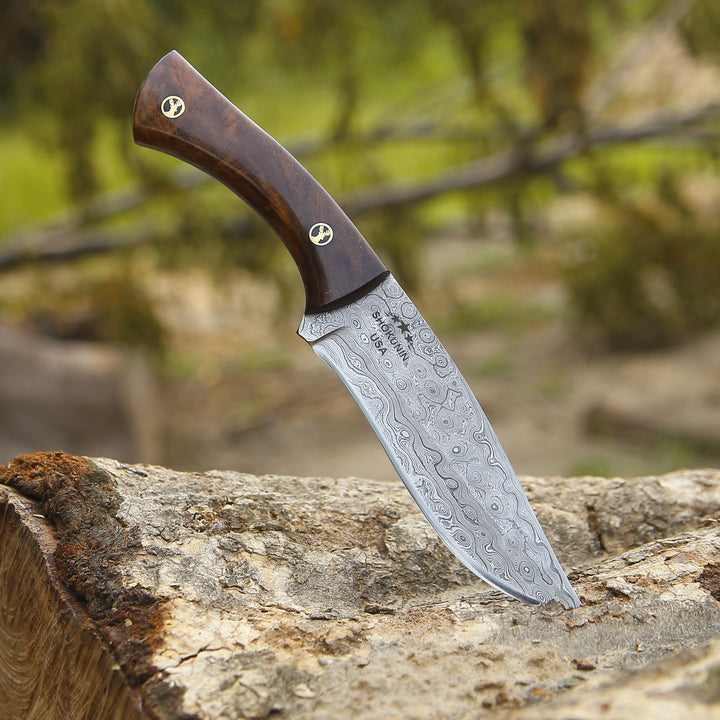 Decorative knife with a wooden handle on a tree stump