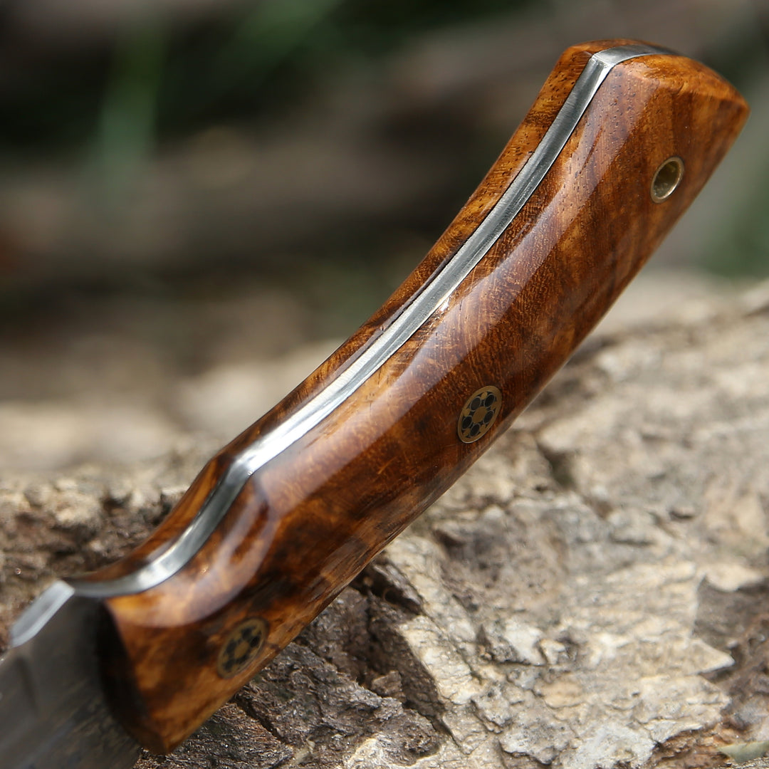 Wooden-handled knife with metal blade on a stone surface