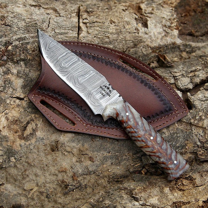 Decorative knife with a brown leather sheath on a wooden surface
