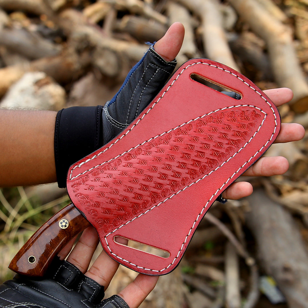 Red leather knife sheath held by a person with a blurred natural background