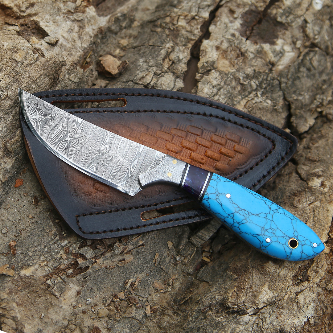 Knife with a blue handle and brown sheath on a textured surface