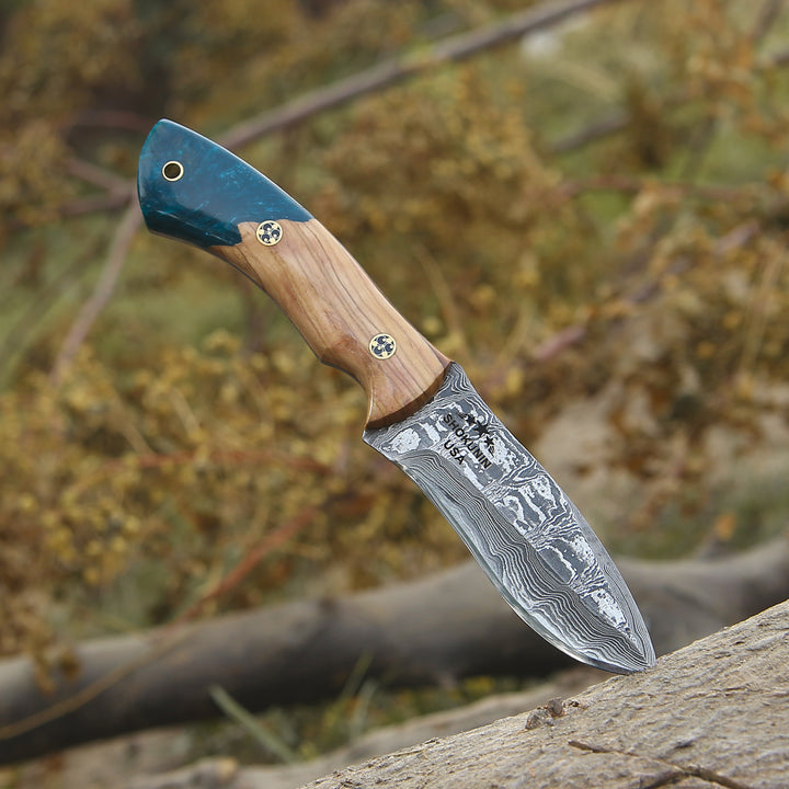 Decorative knife with a wooden handle and engraved blade on a natural background