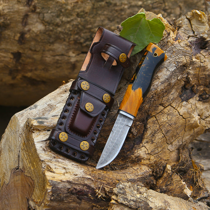 Knife with wooden handle and leather sheath on a wooden surface
